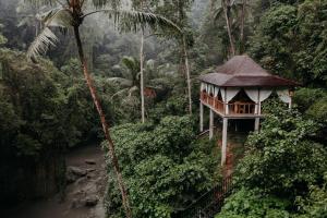 a tree house in the jungle next to a river at Bedulu Cliff Estate Villas Complex Ubud in Ubud