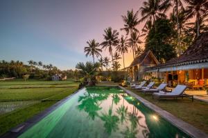 une villa avec une piscine en face d'une maison dans l'établissement Villa O'Hea Ubud, à Ubud