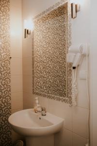オレシニツァにあるHotel Gardenのバスルーム(白い洗面台、鏡付)