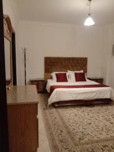 a bedroom with a large bed with red pillows at Dar Al Riyadh Apartments in Riyadh