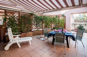 un patio con mesa, sillas y plantas en Residence La Rosa di Nettuno en Marina di Grosseto