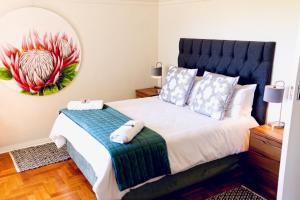 a bedroom with a large bed and a mirror at Mouille Point Villa Capri in Cape Town