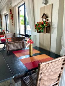 a dining room with a table with chairs and flowers at Hotel Flat Classic in Fortaleza