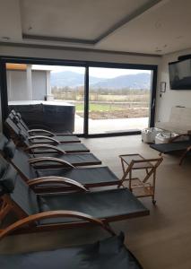 a group of chairs in a room with a large window at HIRUNDO- villa with saunas and hot tub 