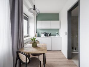 - une cuisine avec une table et des chaises dans la chambre dans l'établissement limehome Saarbrücken Berliner Promenade, à Sarrebruck