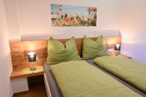 een slaapkamer met 2 bedden en groene kussens bij Biohof Auinger, der Tiererlebnishof in Aurach am Hongar