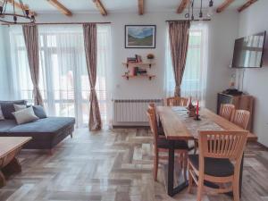 uma sala de estar com uma mesa e um sofá em Villa Tangra em Grashtitsa