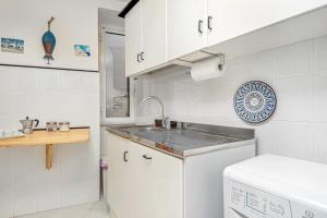 a white kitchen with a sink and a dishwasher at La Bella Vita in Vernazza