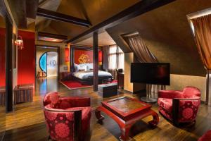 um quarto de hotel com uma cama e cadeiras vermelhas em Buddha-Bar Hotel Prague em Praga
