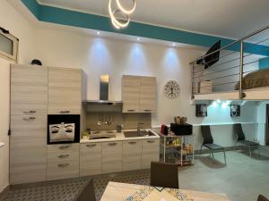 a kitchen with white cabinets and a blue ceiling at Casa vacanza toledo in Partinico