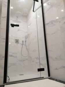 a bathroom with a shower with white marble at l'Antre coquin in Béthune