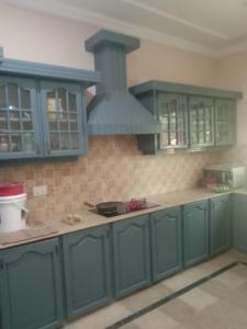 a kitchen with blue cabinets and a stove at Impeccable 4-Bed Villa in Mirpur azad khasmir in Pothi