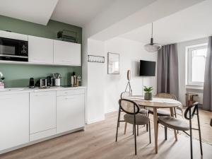 uma cozinha e sala de jantar com mesa e cadeiras em limehome Saarbrücken Berliner Promenade em Saarbrücken