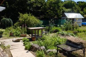 un jardin avec une table en bois et un banc dans l'établissement 犬と泊まれる平屋Dog friendly house 黄昏, à Misaki