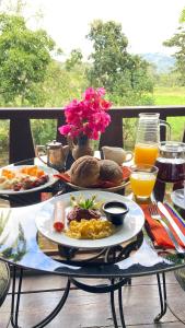 a breakfast table with a plate of food and orange juice at Garden Hotel in Copán Ruinas