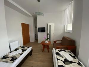 Habitación con 2 camas y sala de estar. en Guest House Penzión Fortuna, en Tvrdošín