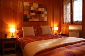 een slaapkamer met een groot bed met 2 lampen bij [Chalet Villa Maria] con Vista Montagne - Netflix in Mesocco