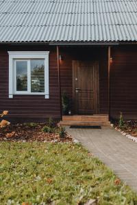 Casa con puerta de madera y porche en Alejas apartamenti en Augšlīgatne