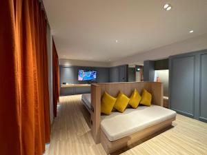 uma sala de estar com um sofá com almofadas amarelas em Banlansuan Resort SHA Plus em Cha Am