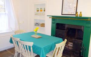 a dining room with a green table and chairs at Cherry Cottage, Youlgrave Nr Bakewell in Youlgreave +4 photos