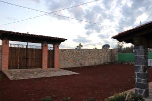 een bakstenen hek met een hek en een stenen muur bij Casa Aralias in Zacatlán