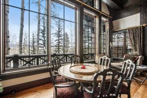 a dining room with a table and chairs and large windows at Daybreak Ridge in Avon