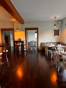 a living room with wooden floors and tables and chairs at Landhaus Spickermann in Xanten