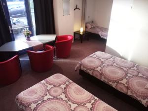 a room with two beds and a table and chairs at B&B Zevenkamp in Rotterdam