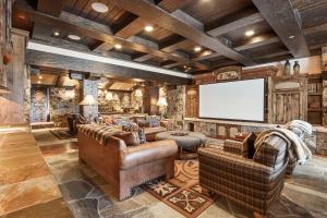 a living room with leather furniture and a screen at Daybreak Ridge in Avon