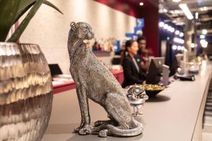 a silver statue of a dog sitting on a table at ibis Styles Muenchen Perlach in Munich