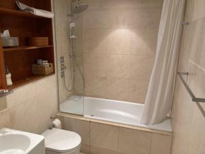 ein Bad mit einer Dusche, einem WC und einem Waschbecken in der Unterkunft Loft in Haggerston in London