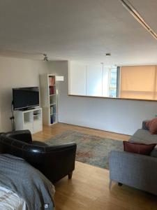 a living room with a couch and a tv at Loft in Haggerston in London