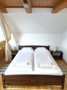 エゲルにあるBorház Apartmanのベッドルーム(白いシーツを使用した大型ベッド1台付)