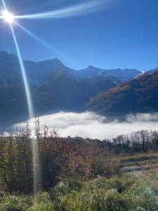 a view of a mountain with the sun shining over the clouds at DUPLEX Les Plautus in Orcières