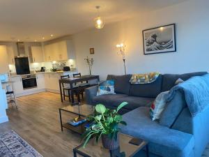 a living room with a blue couch and a kitchen at The Retreat in Weston-super-Mare