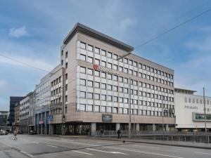 a large building with a sign on it on a street at limehome Saarbrücken Berliner Promenade in Saarbrücken