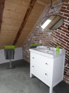 a bathroom with a white sink and a brick wall at Ferienwohnung Gulf im Gulfhof am Kanal in Großefehn 