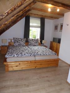 a bedroom with a wooden bed in a room at Ferienwohnung Gulf im Gulfhof am Kanal in Großefehn 