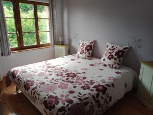 a bedroom with a bed with a floral comforter at La Belle Charbonnière in La Grande Fosse