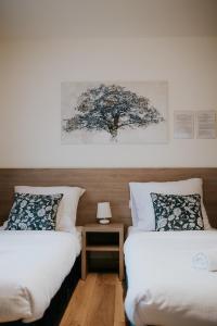 - une chambre avec 2 lits et un arbre sur le mur dans l'établissement Villa Garden, à Oleśnica