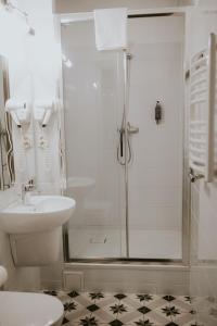 La salle de bains est pourvue d'une douche et d'un lavabo. dans l'établissement Villa Garden, à Oleśnica