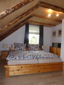 a bedroom with a wooden bed with a window at Ferienwohnung Gulf im Gulfhof am Kanal in Großefehn 