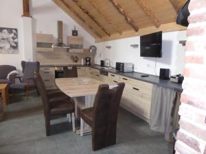 a kitchen with a table with chairs and a television at Ferienwohnung Gulf im Gulfhof am Kanal in Großefehn  +6 photos