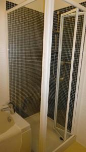a shower with a glass door next to a sink at Cherry Cottage, Youlgrave Nr Bakewell in Youlgreave