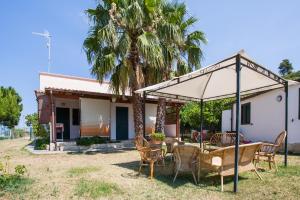 a table and chairs under an umbrella in front of a house at One Love apartments in Lupetto