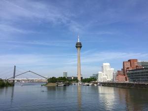 a view of a city with a tower in the water at Düs Apartment 3 in Düsseldorf