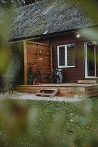 une cabane en rondins avec une terrasse et une table dans l'établissement Alejas apartamenti, à Augšlīgatne