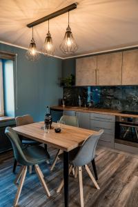 cocina con mesa de madera y sillas en Alejas apartamenti en Augšlīgatne