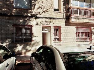 un coche blanco estacionado frente a un edificio de ladrillo en Acogedora Habitación en Madrid, en Madrid