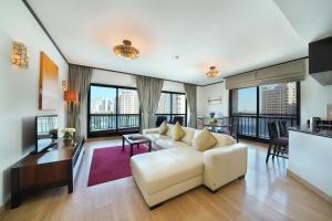 a living room with a white couch and floor to ceiling windows at Park Apartments Dubai, an Edge By Rotana Hotel in Dubai